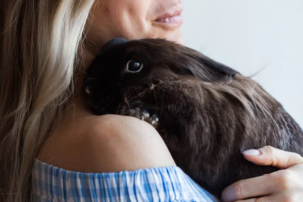 Pet och påsk koncept - Attraktiv flicka kramar brun kanin hemma, närbild. — Stockfoto