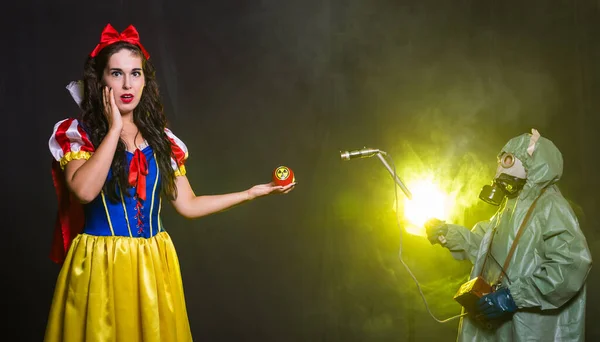Жінка, одягнена як казковий персонаж, тримає на яблуці попереджувальний символ радіоактивної атомної ядерної радіаційної небезпеки. Концепція вимірювання ядерної енергії та радіації . — стокове фото