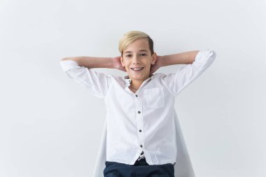 Yalnızlık, yalnızlık ve can sıkıntısı konsepti - Beyaz arka planda izole bir okul koltuğunda oturan sıkıcı genç öğrenci