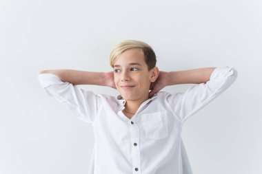 Yalnızlık, yalnızlık ve can sıkıntısı konsepti - Beyaz arka planda izole bir okul koltuğunda oturan sıkıcı genç öğrenci