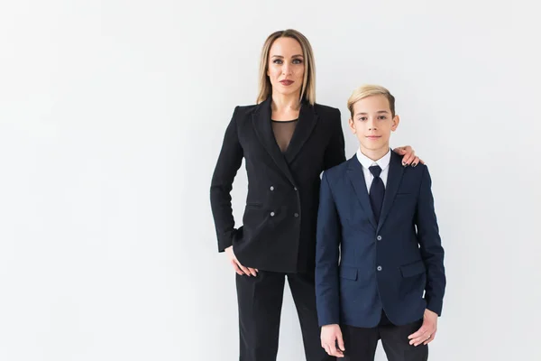 Adolescent et parent célibataire - Jeune mère et son fils debout ensemble sur fond blanc . — Photo