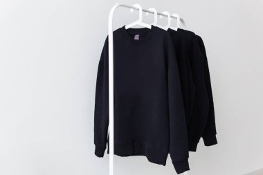 Mağazadaki askılarda asılı eşofman altı ve kapüşonlular. Sokak modası, unisex ve gençlik.
