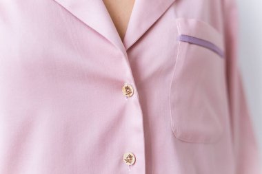 Güzel pembe pijama giymiş, oturma odasında poz veren bir kadın. Rahat uyku giysileri, ev rahatlığı ve kadın moda konsepti..