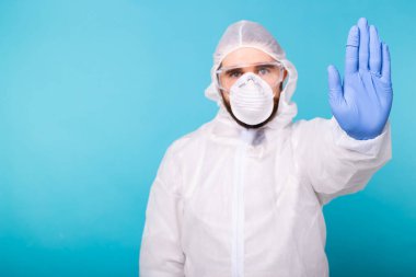 Doktor ya da laboratuvar bilimcisi biyolojik tehlike önleyici giysi giymiş el kol hareketi yaparak Coronavirus COVID-19 hastalığını durduruyor küresel salgın. Giriş yasak, karantina emri..