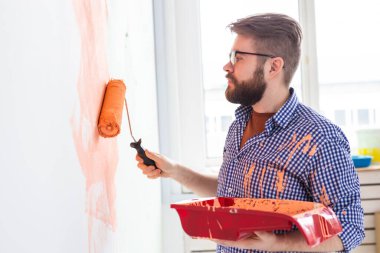 Yeni evin içini boyayan adam. Dekorasyon, yenileme, apartman onarımı ve ferahlatıcı konsept.
