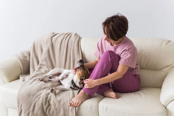 Jeune belle femme à la maison avec son chien mignon. Quarantaine, isolement, monde pandémique de coronavirus. Reste à la maison. . — Photo