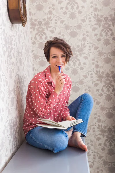 Ragazza seduta su cassettiera a casa . — Foto Stock