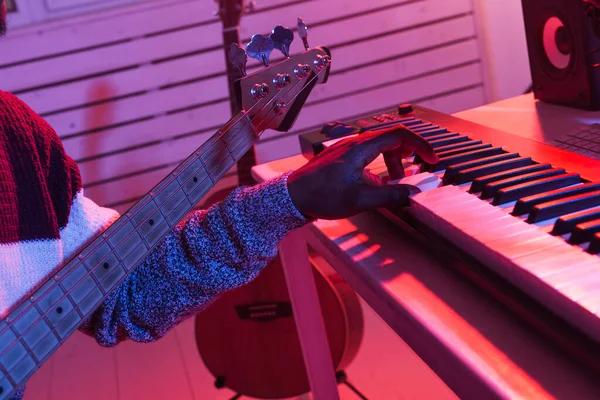 Crear música y un concepto de estudio de grabación - hombre afroamericano guitarrista de grabación de bajo eléctrico pista de guitarra en el estudio en casa, primer plano . — Foto de Stock