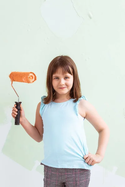 Ragazzo in piedi con il rullo di vernice in mano. Sta dipingendo il muro. Ridecorazione, riparazione e riverniciatura concetto . — Foto Stock