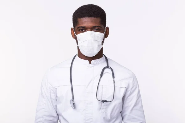 Αφροαμερικανός γιατρός με μάσκα πάνω από λευκό φόντο. Η ιατρική, η υγειονομική περίθαλψη και οι άνθρωποι. — Φωτογραφία Αρχείου