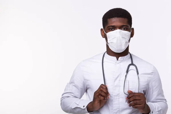 Médecin afro-américain masqué sur fond blanc avec espace de copie. Médecine, santé et personnes concept . — Photo