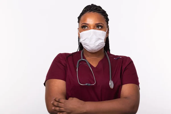 Beyaz bir geçmişi olan, tıbbi maskeli Afrikalı Amerikalı bir doktor. Tıp, sağlık ve insan konsepti.
