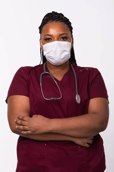 Beyaz bir geçmişi olan, tıbbi maskeli Afrikalı Amerikalı bir doktor. Tıp, sağlık ve insan konsepti.