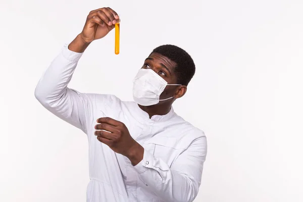 Glass tube with yellow fluid in doctor hand during medical test. Vaccine development, experiments and science concept.