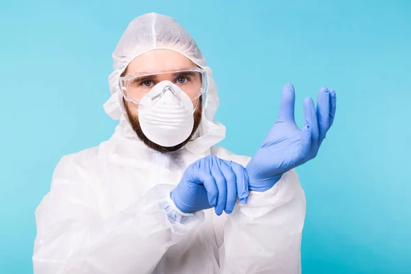 Професійна робота з дезінфекції. Епідеміолог вдягає захисний костюм і рукавички. Coronavirus, covid-19 and pandemic concept. — стокове фото