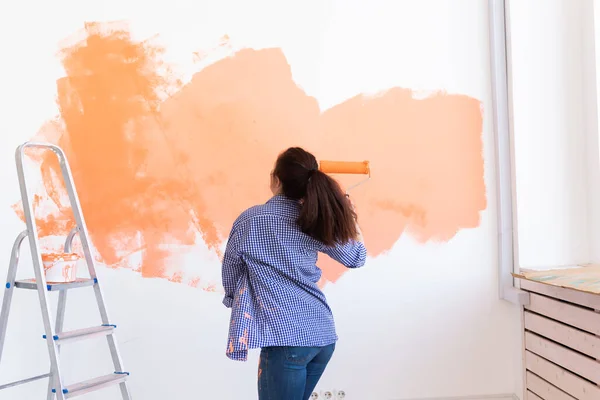 Ballando donna divertente pittura muro nel suo nuovo appartamento. Concetto di ristrutturazione e ridecorazione . — Foto Stock