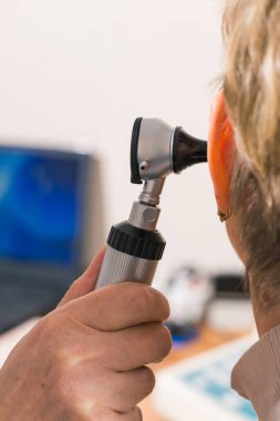 Doktor, hastanede kadınların kulaklarını kontrol etmek için otoskop aleti kullanıyor Coronavirus Covid19 salgınında sağlık görevlileri....