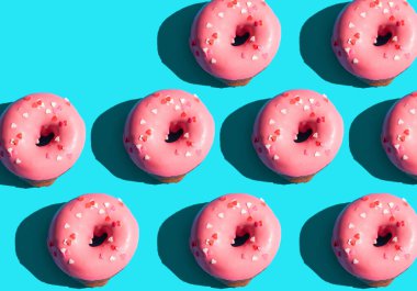 Moda güneş ışığı. Açık mavi turkuaz arka planda pembe donutla yapılmış yaz deseni. Minimum yaz konsepti. Pop sanat tarzı. Çörek.
