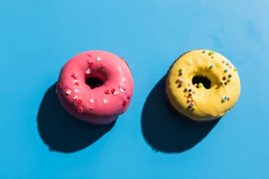 Moda güneş ışığı. Açık mavi turkuaz arka planda yaz çörekleri. Minimum yaz konsepti. Pop sanat tarzı. Çörek.