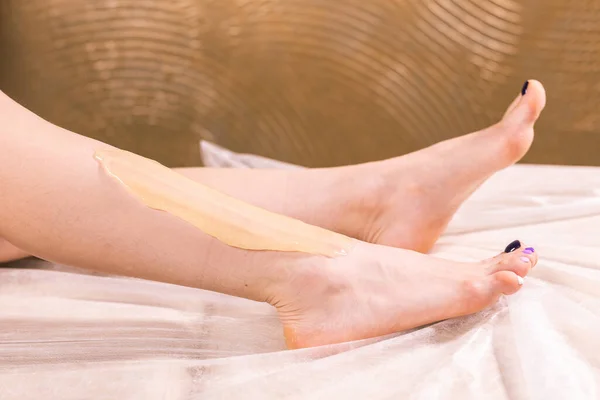 Suiker epilatie huidverzorging met vloeibare suiker aan de benen. Je kunt haar gladde en haarvrije benen zien na het verwijderen van haar close-up. Schoonheids- en kosmetologisch concept. — Stockfoto