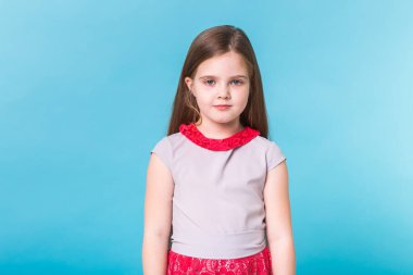 Mavi arka planda izole edilmiş güzel küçük bir kız. Çocukluk ve çocuk kavramı.