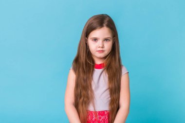 Mavi arka planda izole edilmiş güzel küçük bir kız. Çocukluk ve çocuk kavramı.