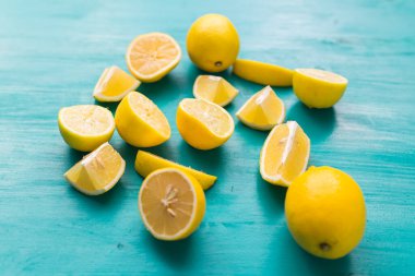 Taze kesilmiş yarım limon ve tüm limonlar kırsal akuamarin renk tahtalarında. Yaz, vitaminler ve tazelik konsepti.