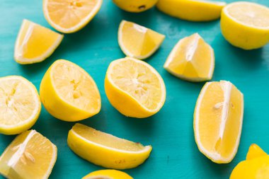 Taze kesilmiş yarım limon ve tüm limonlar kırsal akuamarin renk tahtalarında. Yaz, vitaminler ve tazelik konsepti.