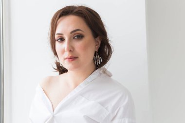 Küpeli zarif bir kadın, yakın portre. Aksesuarlar, mücevherler ve bijouterie konsepti.