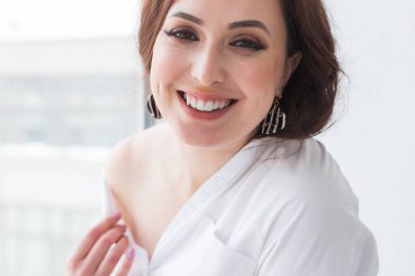 Küpeli zarif bir kadın, yakın portre. Aksesuarlar, mücevherler ve bijouterie konsepti.