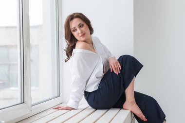 Zarif saç stili, lüks mücevherleri ve bijouterisi olan güzel bir genç kadının yakın plan portresi..