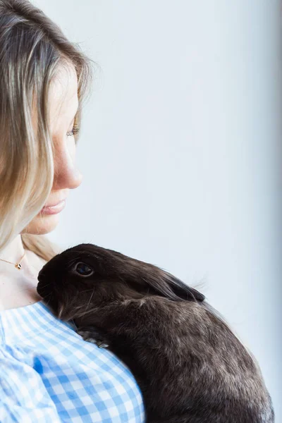 Evcil hayvan ve Paskalya konsepti - Mutlu kız evde kahverengi tavşana sarılıyor. — Stok fotoğraf