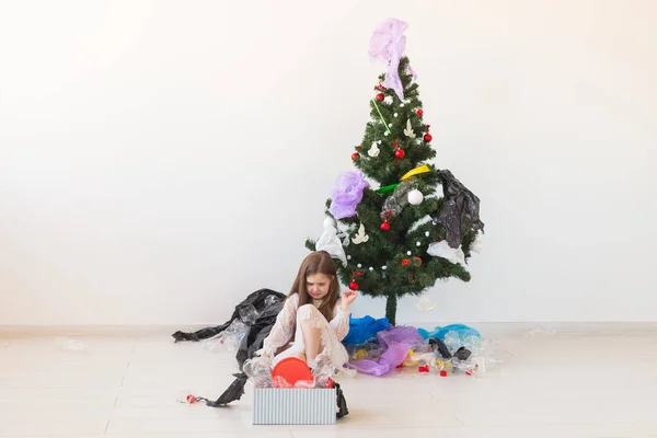 Protección del medio ambiente y concepto de contaminación. Caja de transporte infantil sorprendida con basura de plástico sobre el fondo del árbol de Navidad . — Foto de Stock