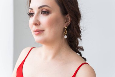 Küpeli zarif bir kadın, yakın portre. Aksesuarlar, mücevherler ve bijouterie konsepti.