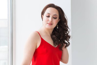 Zarif saç stili, lüks mücevherleri ve bijouterisi olan güzel bir genç kadının yakın plan portresi..