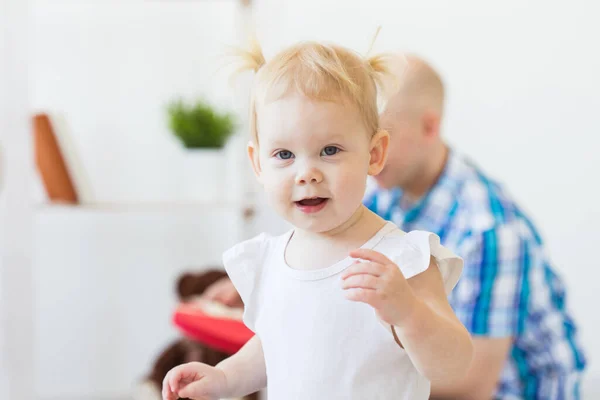 Lustig liten flicka som leker i vardagsrummet. Barn- och familjebegreppet. — Stockfoto