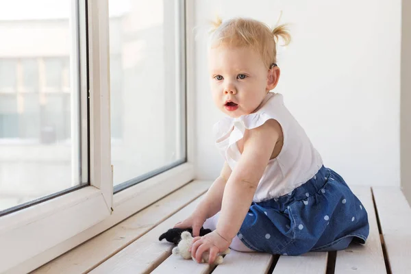 Hearing aid in baby girls ear. Toddler child wearing a hearing aid at home. Disabled child, disability and deafness concept. — Stock Photo, Image