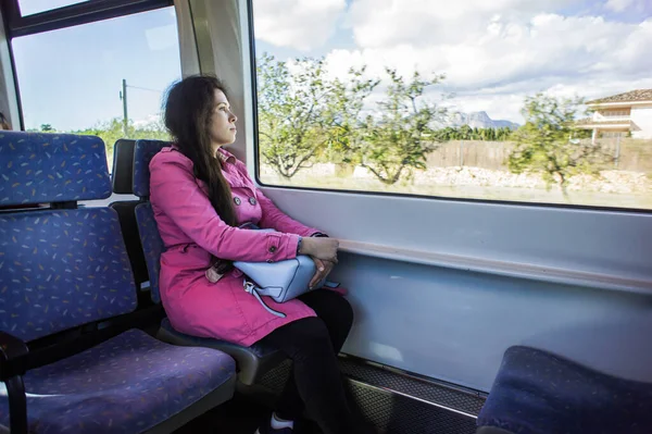 Young woman traveling by train. Travel, transport and vacation concept.