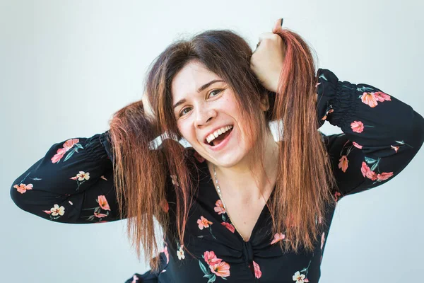 Playful and happy funny redhead woman having fun laughing on a white background.