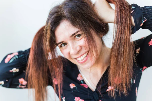 Playful and happy funny redhead woman having fun laughing on a white background.