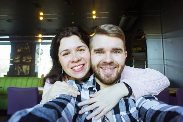 Una pareja encantadora tomando selfie en el café. Tecnologías y concepto fotográfico . —  Fotos de Stock