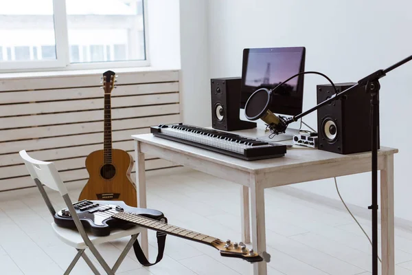 Micrófono, ordenador y equipo musical guitarras y fondo de piano. concepto de estudio de grabación en casa . —  Fotos de Stock