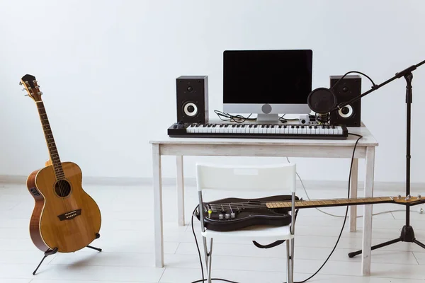 Mikrofon, dator och musikalisk utrustning gitarrer och piano bakgrund. Heminspelning studio koncept. — Stockfoto