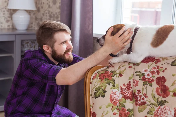 Close Up retrato bonito jovem hipster homem joga e ama seu bom amigo cão em casa. Emoções humanas positivas, expressão facial, sentimentos . — Fotografia de Stock