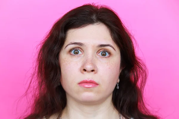 Surpreendido assustado jovem mulher no fundo rosa — Fotografia de Stock