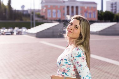 Parkta gülümseyen güzel sarışın kadın. Yaz, tatil ve tatil konsepti.