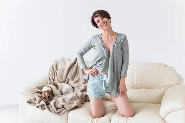 Jovem mulher bonita em casa com seu cão bonito. Quarentena, isolamento, mundo de pandemia de coronavírus. Fique em casa . — Fotografia de Stock