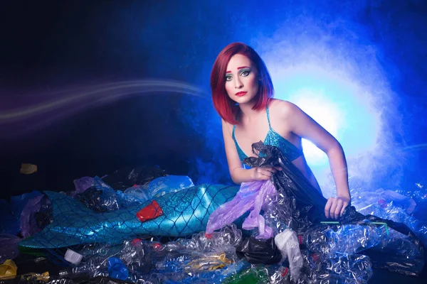 Ocean plastic pollution. Cute mermaid swimming in water with plastic garbage. Stop plastic pollution. Fairy tale and reality concept.