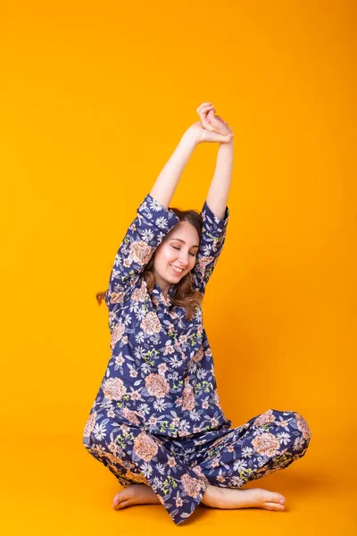 Moda portresi oldukça havalı bir kız renkli sarı arka planda eğleniyor. Pijama ve ev kıyafetleri konsepti — Stok fotoğraf