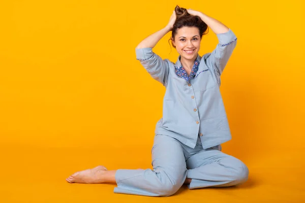 Acercamiento mujer joven en ropa de casa azul. Aislado sobre fondo amarillo. Concepto de pijama . — Foto de Stock